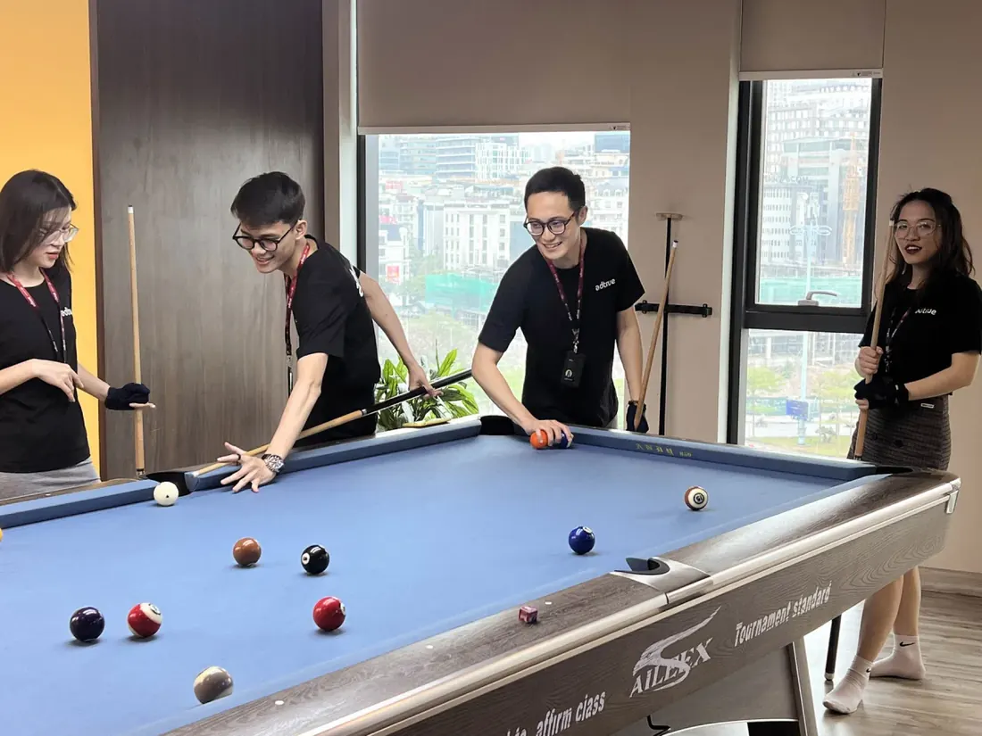 Team members playing billiards in the AdTrue lounge